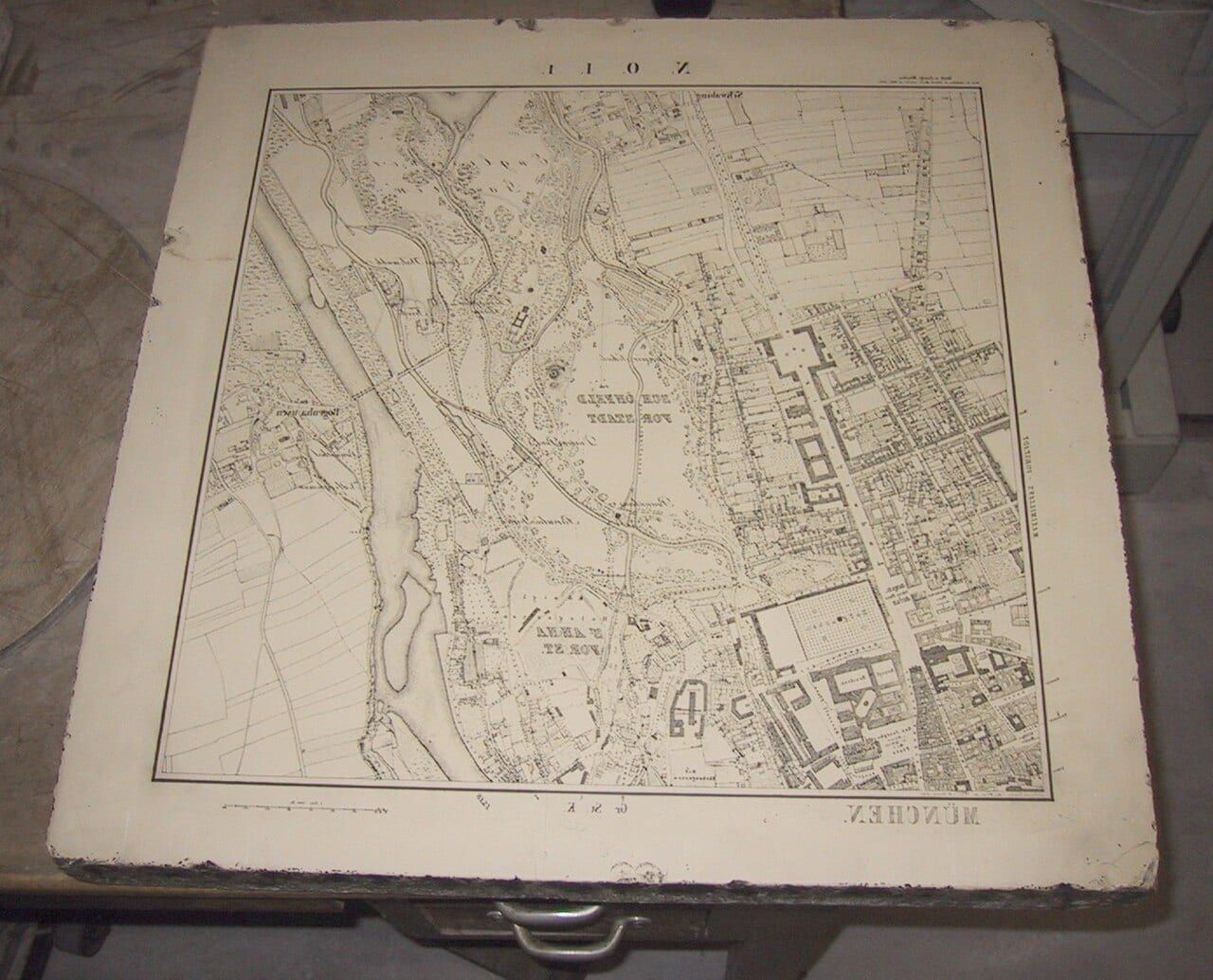 A lithographic stone carrying a map of Munich; the image is drawn in reverse so that it prints the right way round