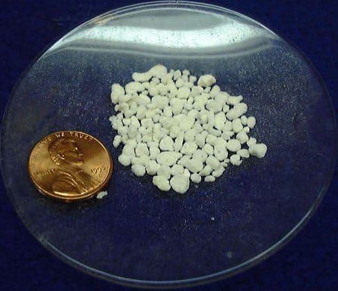 A sample of raw perlite; the coin gives the scale